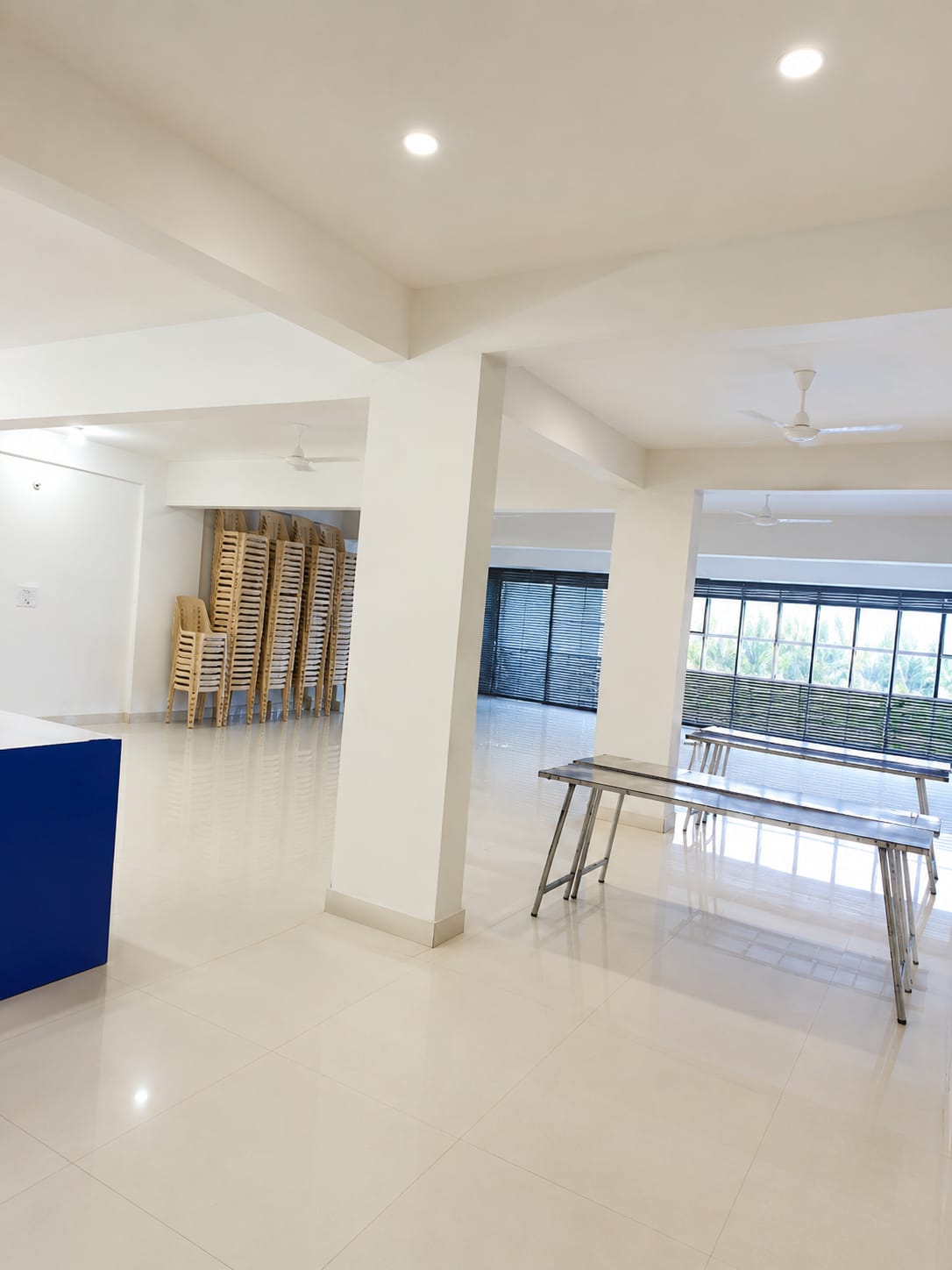 Spacious dining hall with stacked chairs and serving tables